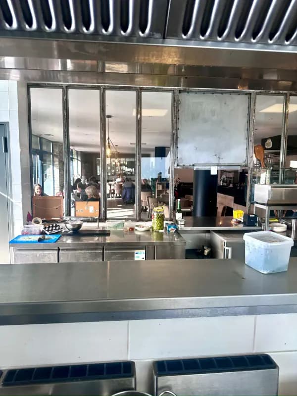 La salle du restaurant, conviviale et chaleureuse, vue de la cuisine.